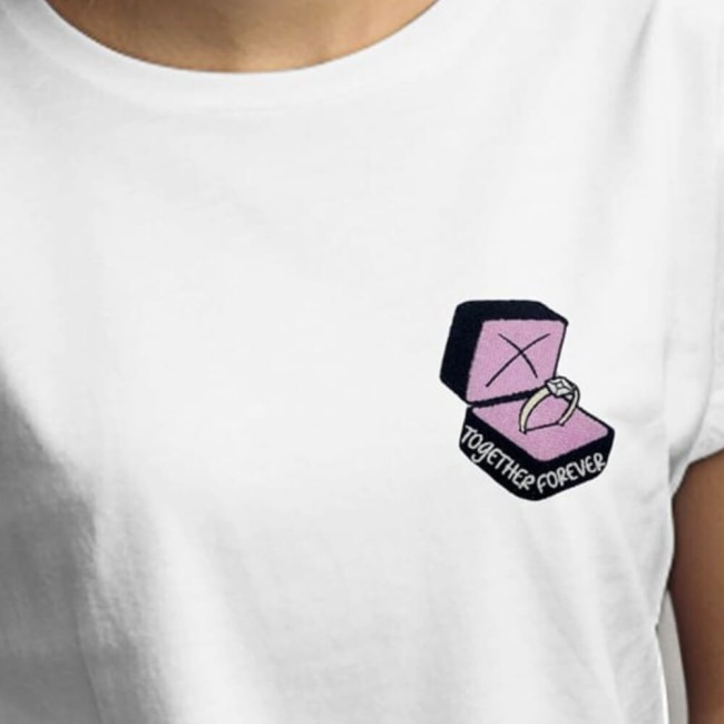 Écusson bague brodée rose poudré sur un tee-shirt blanc