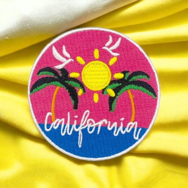 Patch brodé California à plat, palmiers noirs et verts sur fond rose et bleu