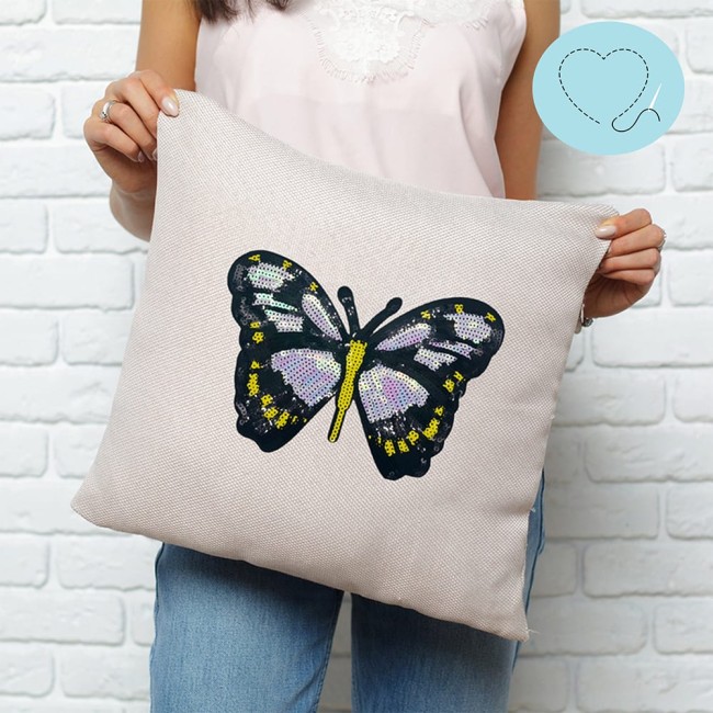 Écusson papillon cousu sur coussin beige