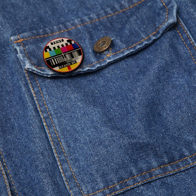 Pin’s Mire TV fixé sur une poche de veste en jean