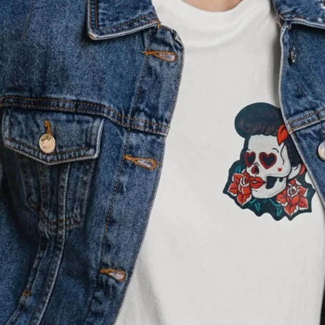 Patch brodé rétro coloré avec crâne style Catrina thermocollé sur une veste en jean Patch pin-up rockabilly brune porté sur un tee-shirt blanc