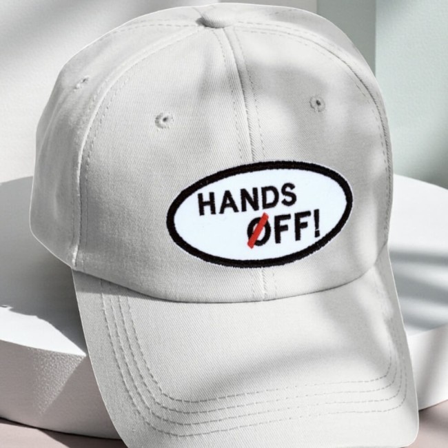 Patch ovale Hands Off brodé rouge et blanc sur une casquette blanche
