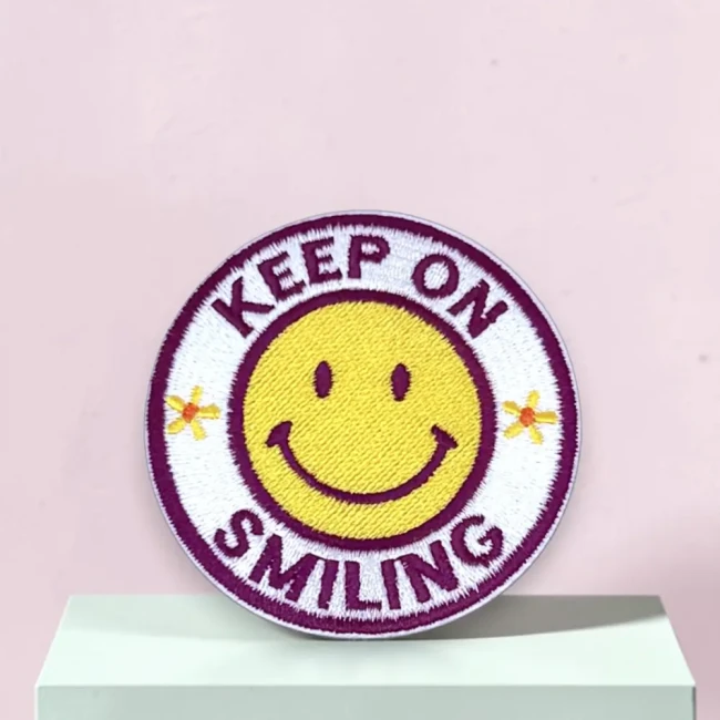 Patch brodé Keep on Smiling sur fond rose