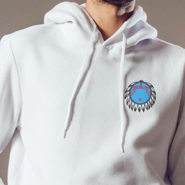 Écusson tribal bleu et rouge posé sur un hoodie blanc