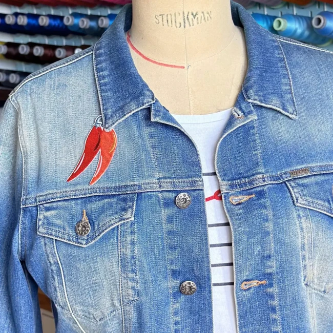 patch brodé piments sur une veste en jean