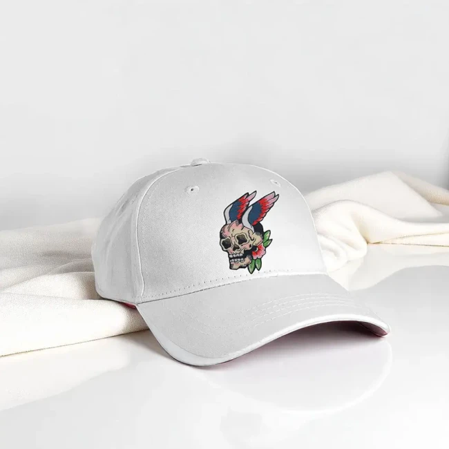 Ecusson thermocollant tête de mort avec ailes posé sur casquette blanche Patch brodé crâne ailé biker style tattoo sur une casquette