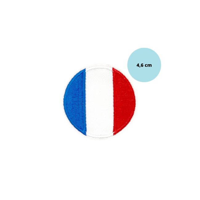 Gros plan sur le patch rond tricolore posé à la verticale sur une surface blanche, capturant la netteté des contours brodés.