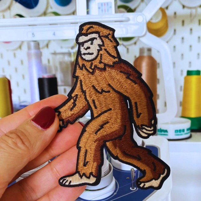 Patch Bigfoot brodé tenu à la main devant ma machine à broder professionnelle
