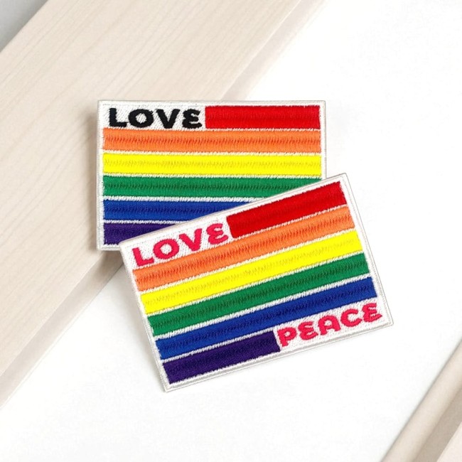 Ecusson brodé thermocollant Love & Peace inclusif Gros plan sur la broderie arc-en-ciel et le texte LOVE PEACE