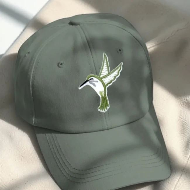 Patch colibri vert posé sur une casquette kaki