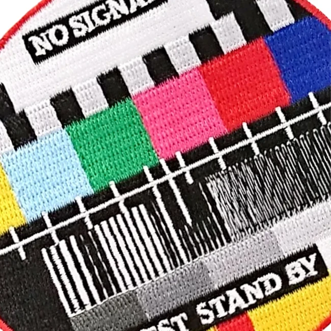 Détail de la broderie de l'écusson mire TV Gros plan du patch mire TV avec message Test Stand By