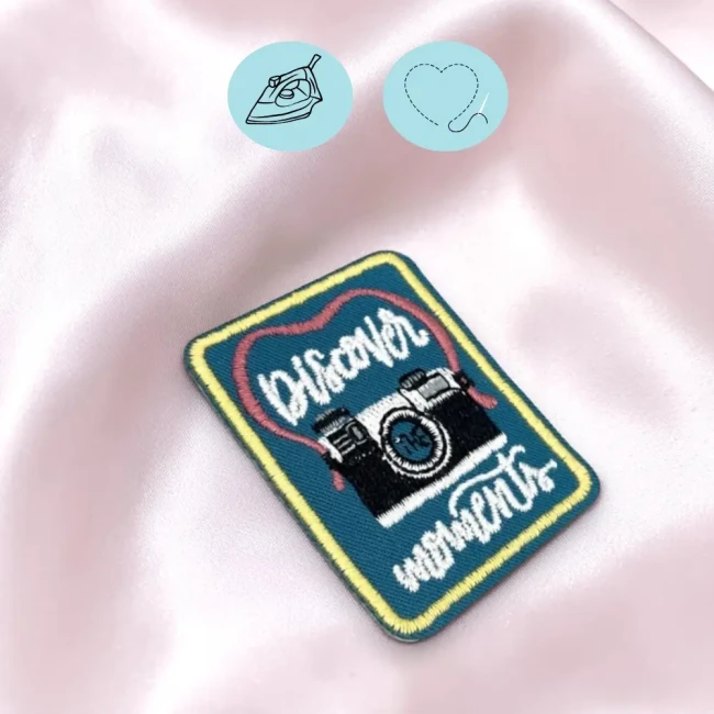 Patch appareil photo thermocollant posé sur un tissu rose