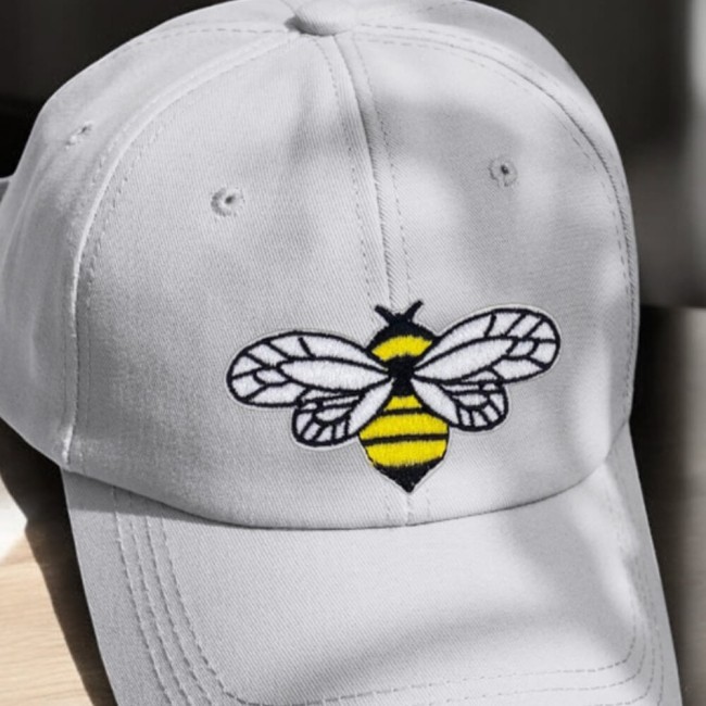 Casquette grise customisée avec une abeille jaune, blanche et noire