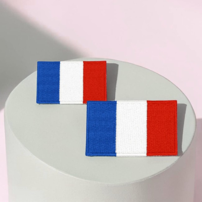 Patch rectangle bleu blanc rouge en pleine lumière naturelle, soulignant les détails de la broderie