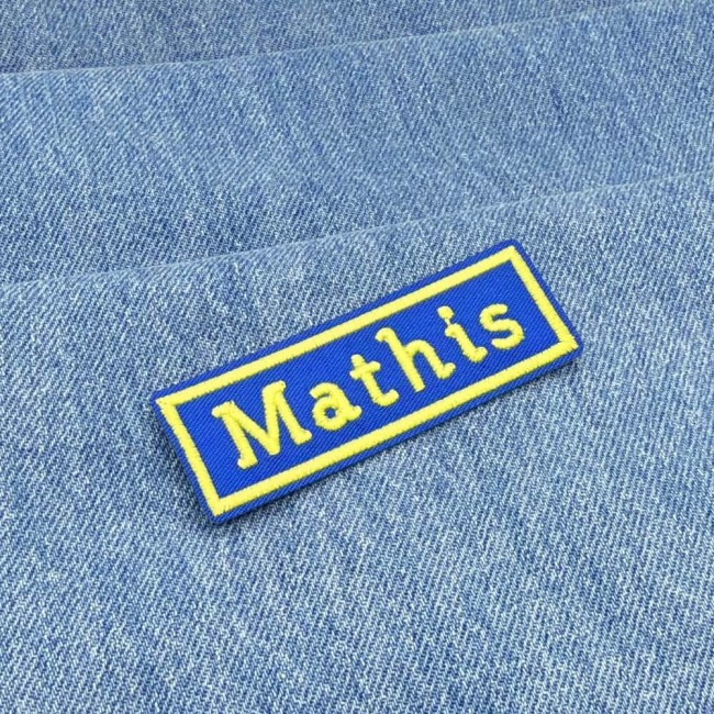 Patch nom Mathis sur denim Patch nom Mathis brodé en bleu et jaune posé sur jean