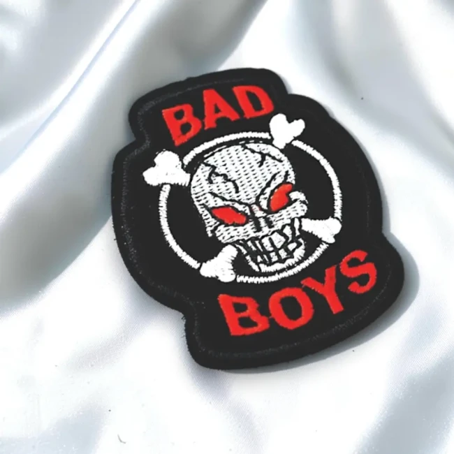 Patch Bad Boys tête de mort posé sur un tissu satiné blanc
