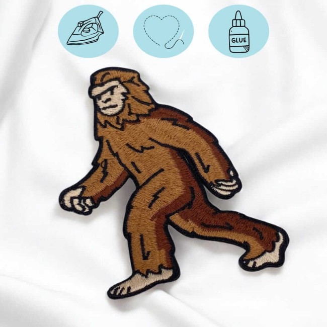 Écusson thermocollant Bigfoot posé sur tissu blanc, prêt à être appliqué
