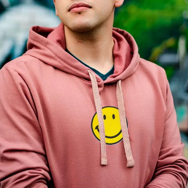 Ecusson vêtement smiley jaune soleil sur un sweatshirt Patch brodé smiley jaune sur un hoodie porté par un homme