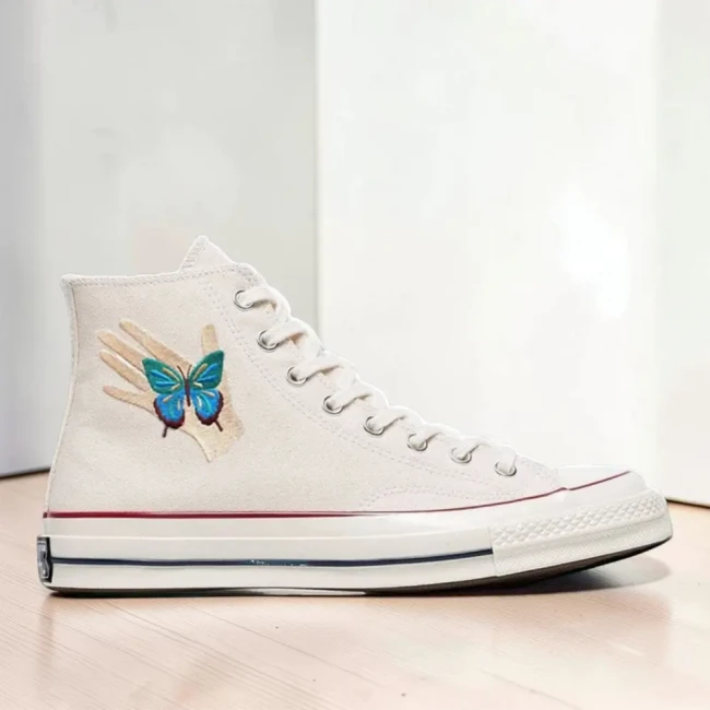 Écusson thermocollant main et papillon sur sneaker Patch main et papillon bleu posé sur une chaussure montante blanche
