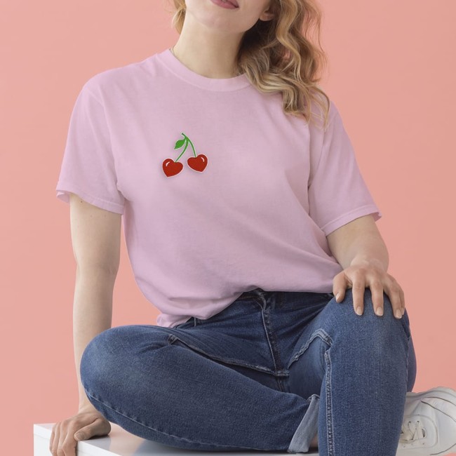 Ecusson cerises cœur brodé – Look cool sur un t-shirt rose Patch brodé cerises cœur appliqué sur un t-shirt rose clair, porté avec un jean.