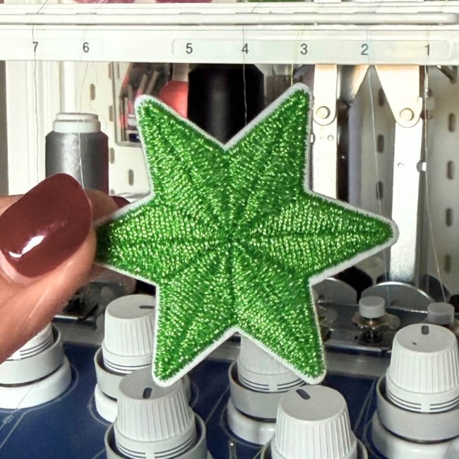 patch étoile brodée dans mon atelier en France Patch étoile verte brodée en fil métallique devant une machine à broder