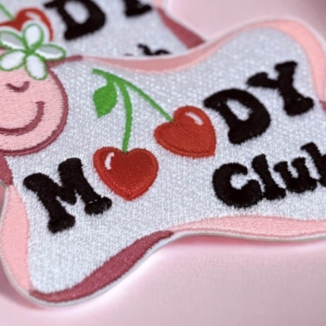 Détail broderie patch Moody Club Gros plan du patch brodé Moody Club avec cerises et smiley fleuri