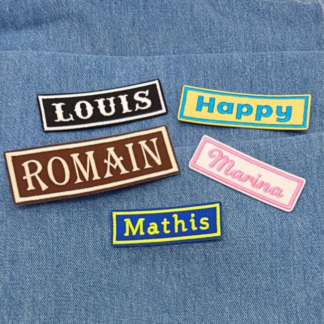 Patchs nom et mots personnalisés sur un jean, brodés dans mon atelier Patchs nom personnalisés brodés posés sur denim avec styles variés