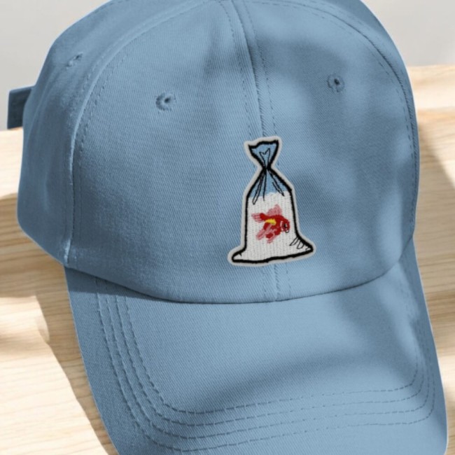 Casquette bleue customisée avec un petit patch poisson rouge