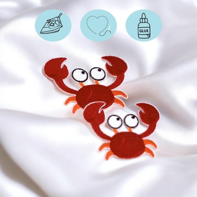 Deux écussons crabes thermocollés sur textile blanc