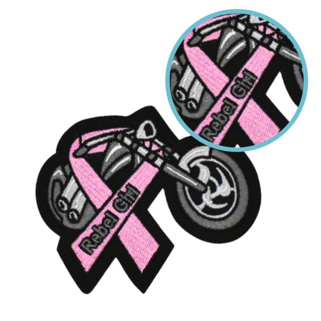 Patch brodé REBEL en rose et noir, placé sur tissu beige