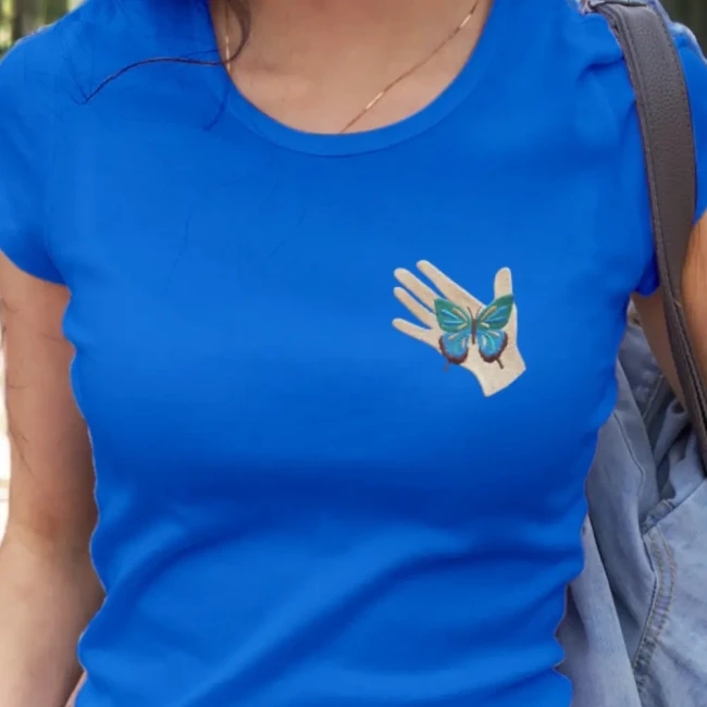 Écusson brodé main et papillon sur tee-shirt Patch main et papillon porté sur un tee-shirt bleu