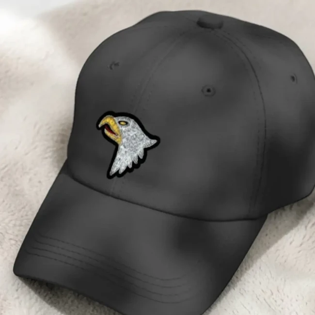 Écusson brodé aigle argenté sur casquette noire Patch tête d’aigle argentée posé sur une casquette noire