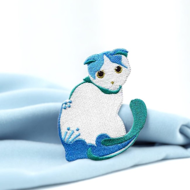 Écusson brodé chat bleu sur fond bois – motif félin mignon