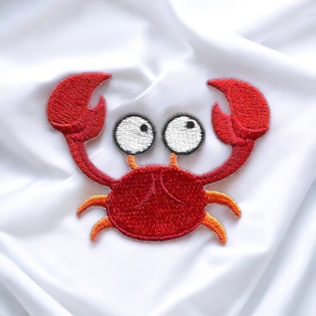 Patch crabe rouge thermocollé sur tissu blanc en lumière douce