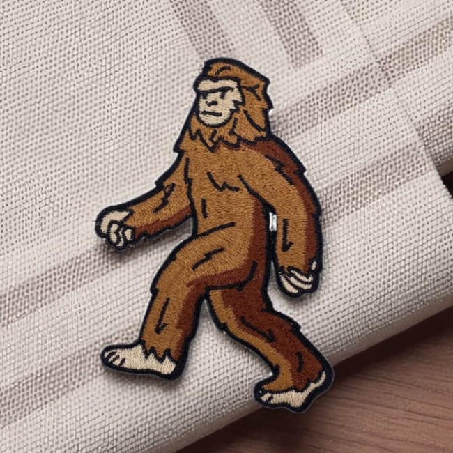 Patch brodé Bigfoot marron vu de face sur fond bois clair
