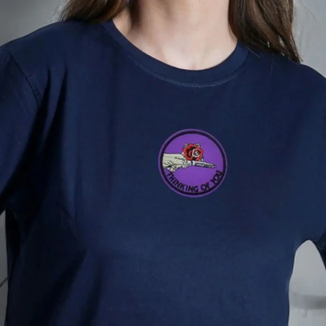 Écusson brodé Thinking of You sur tee-shirt Patch Thinking of You violet porté sur un tee-shirt bleu marine