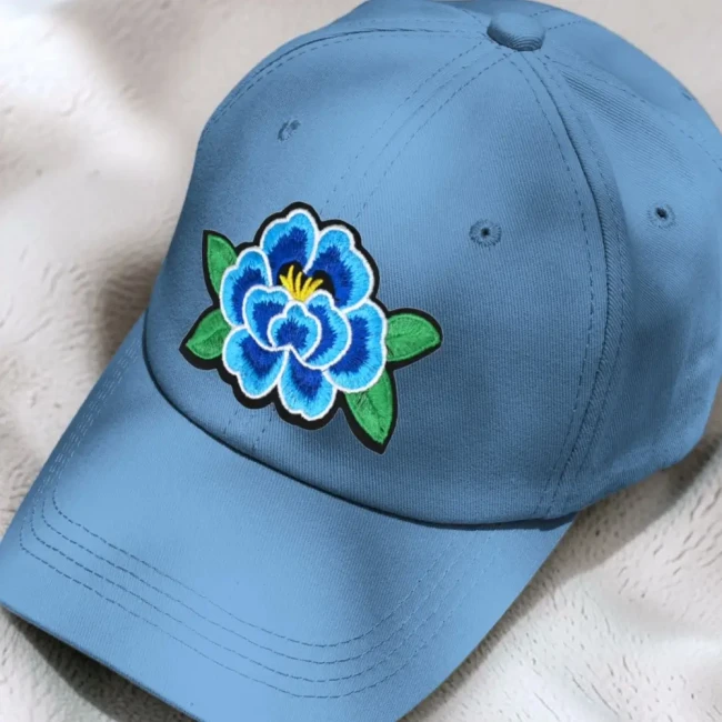 Applique fleur bleue brodée sur casquette Patch fleur bleue brodée présenté sur une casquette bleue
