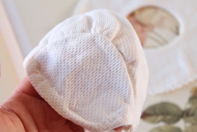 gros plan sur les finitions de couture du petit bonnet ancien pour poupée ou nourrisson