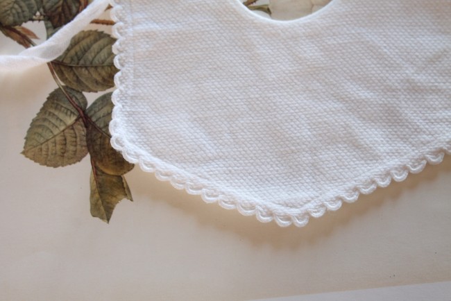 gros plan sur la bordure du bavoir ancien blanc pour poupées ou nourrisson