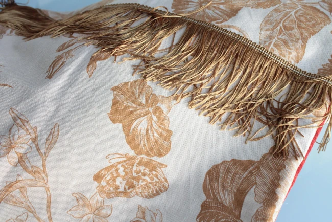 Détail de la frange or du coussin double face
