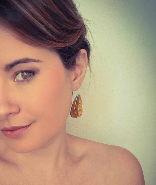 Femme portant le bijou Œuf d’Ambre, boucles dorées légères faites main