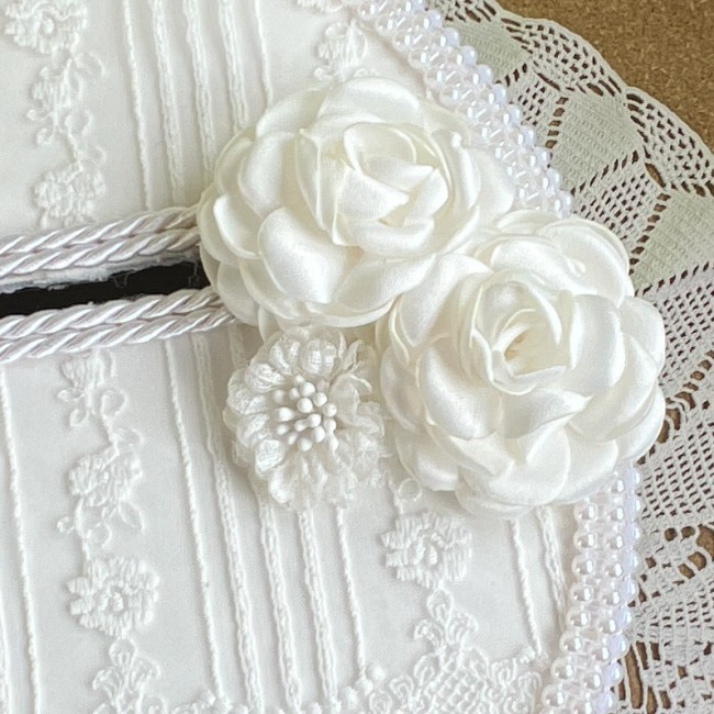 Détail chic de l'urne Chanelle avec fleurs en satin Détail des fleurs et dentelle sur le couvercle coté droit