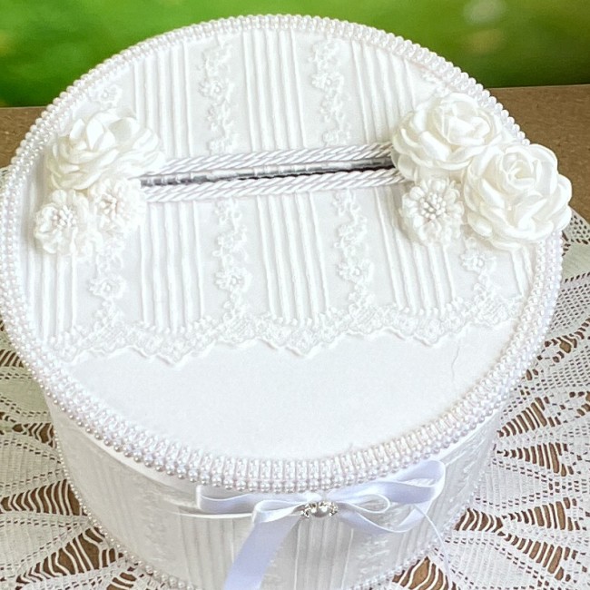 Détail chic de l'urne Chanelle avec fleurs en satin sur le couvercle Détail des fleurs et dentelle sur le couvercle