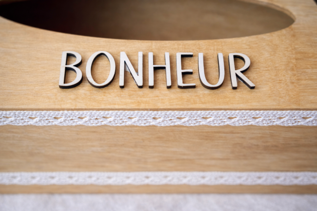 Zoom détail mot BONHEUR décoration mariage Gros plan inscription BONHEUR sur boîte à mouchoirs mariage en bois naturel