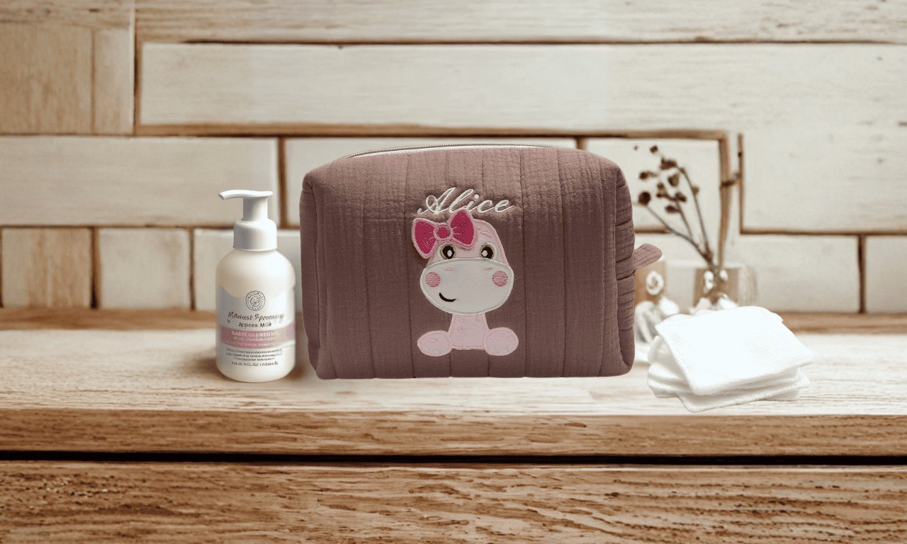 trousse de toilette brodée dinosaure personnalisée prénom Alice posée sur plan en bois  - MaïKa Créations
