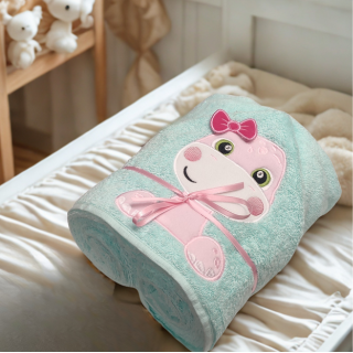 cape de bain bébé brodée dinosaure cape de bain bébé brodée dinosaure posé sur table à langer