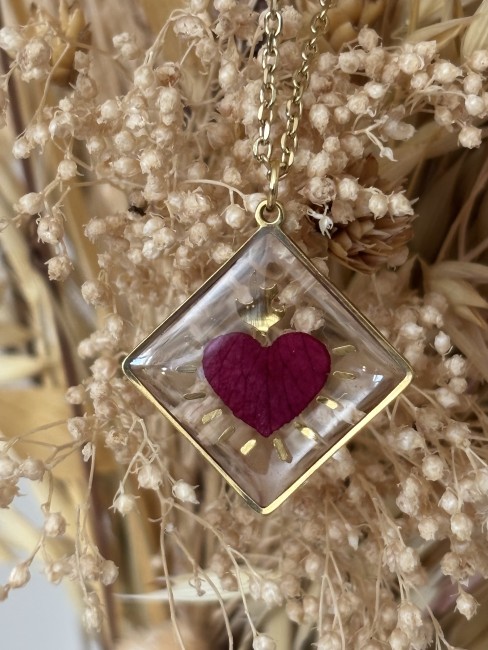 Pendentif cœur ex-voto en pétale de rose porté sur une chaîne dorée.