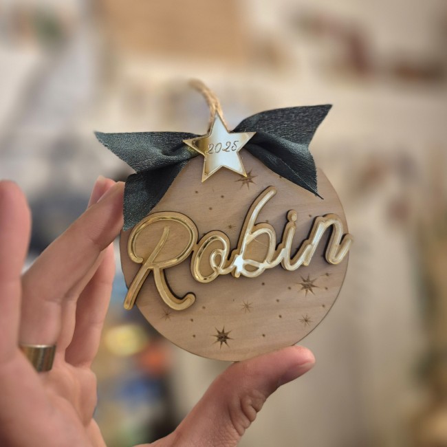 alt=Boule de Noël « Mon Premier Noël » en bois gravé avec prénom et année, l'Atelier de Célestine